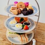 Afternoon Tea selection on tiered plates with pot of tea